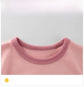 Close-up of the ribbed crew neck and fine knit texture on the pink girls' long sleeve top