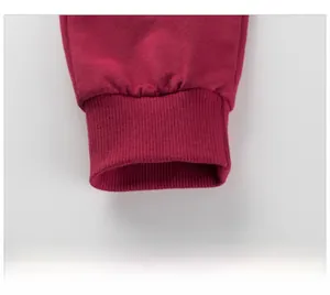 Detail of red elastic ribbed cuffs on autumn cotton sweatpants for girls