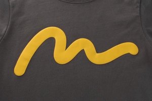 Détail du t-shirt en maille gris foncé avec motif imprimé de vagues jaunes