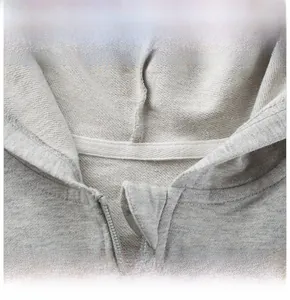 Gros plan du col d'un sweat à capuche gris clair zippé en tissu éponge de coton épais