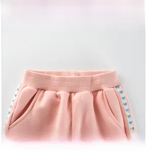 Detail of pink fleece pants featuring elastic waistband and blue heart patterned side tape