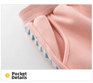 Detail of pink kids pants featuring ribbed waistband and heart embroidery on pocket