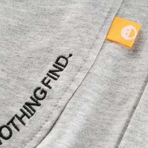 Pantalon de sport gris pour enfants avec broderie noire et étiquette smiley orange