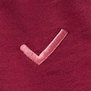 Close-up of wine red children's autumn joggers with pink embroidered checkmark detail