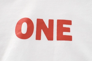 Detail of red ONE print on white cotton long-sleeved t-shirt showing fabric texture
