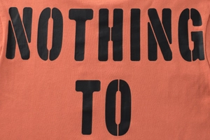 Detail of coral orange cotton T-shirt featuring black NOTHING TO stencil print