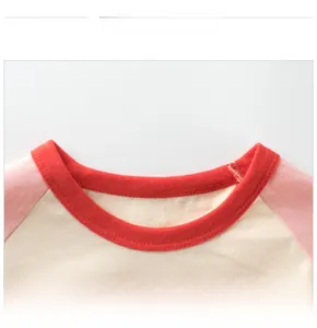 Close-up of contrast crew neck with red ribbed trim and pink raglan sleeves on cotton tee