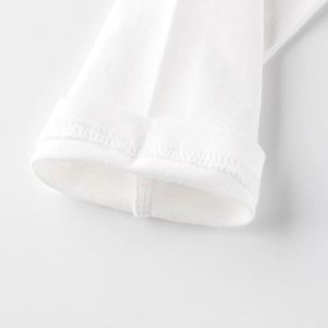 Close-up of white long-sleeved kids' cotton T-shirt showing detailed ribbed cuffs and stitching