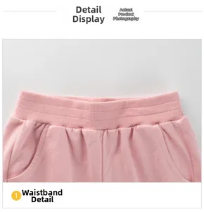 Detail view of pink kids' sports pants featuring an elastic waistband and side pockets