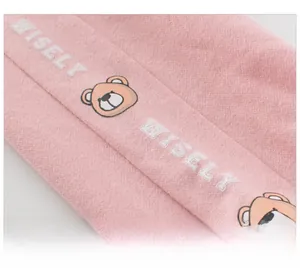 Close-up of pink knit kids sports pants featuring Wisely embroidery and bear prints