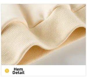 Detailed macro view of the soft ribbed hemline on a beige kids sweatshirt top