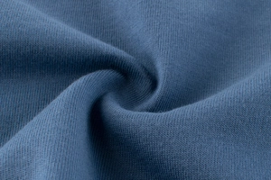 Gros plan détaillé sur la maille de coton bleu gris doux avec un drapé souple et fluide