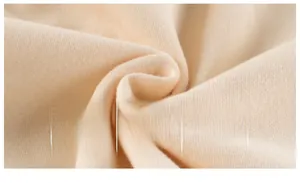 Vue macro montrant la texture douce du tissu polaire abricot pour sweats à capuche