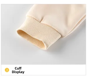 Détail du poignet en tricot côtelé sur un sweat à capuche en polaire beige crème