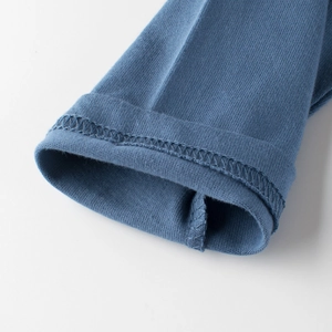 Détail du poignet en coton tricoté bleu avec coutures professionnelles à double aiguille