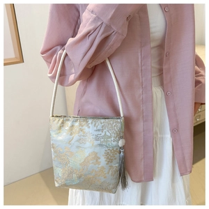 Detail of light blue silk bucket bag with gold Chinese landscape embroidery and tassel