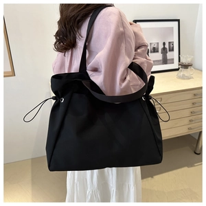 Grand sac fourre-tout noir avec cordon de serrage latéral et bandoulière minimaliste