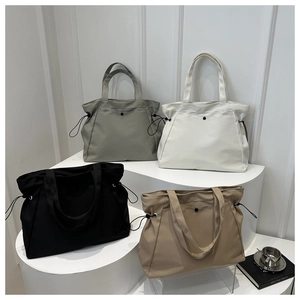 Grands sacs cabas en gris, crème, noir et kaki présentés sur des supports blancs