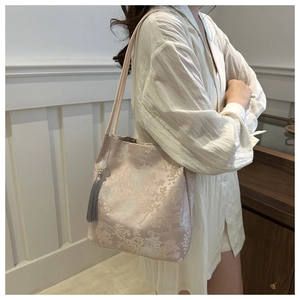 Detail of pink embroidered silk shoulder bag with tassel and scenic landscape motifs