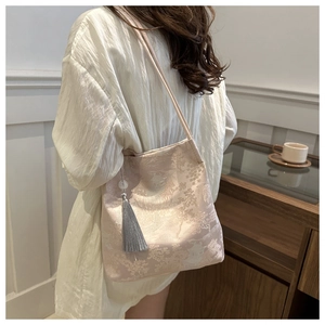Detail of silk texture jacquard tote bag with traditional Chinese landscape and tassel
