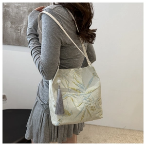 Detail of high-density jacquard fabric with bamboo leaf patterns and gray tassel pendant