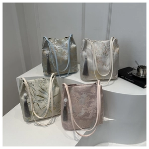 Detail of four jacquard shoulder bags with mountain patterns and tassel charms