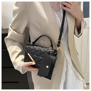 Quilted black crossbody bag with gold hardware detail and mini coin pouch on female model
