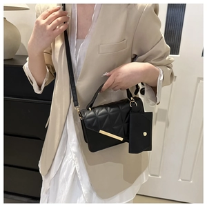 Chic black quilted crossbody bag with gold metal trim and detachable mini pouch accessory