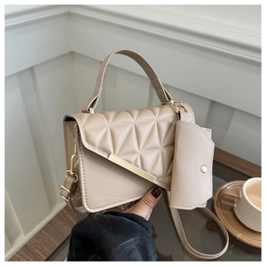 Quilted beige shoulder bag set with small pouch and golden buckle on wooden table