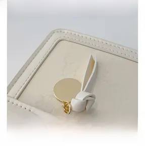 Detail of mini leather bag showing golden metal charm and marble texture patterns