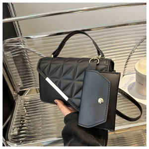 Detail of black quilted leather handbag with mini envelope pouch and silver hardware