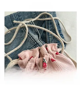 Détail du sac à cordon en velours côtelé rose avec motif floral de fraises
