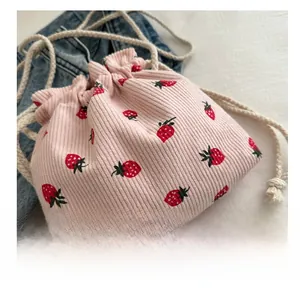 Gros plan du sac seau en velours côtelé rose avec motifs de fraises rouges