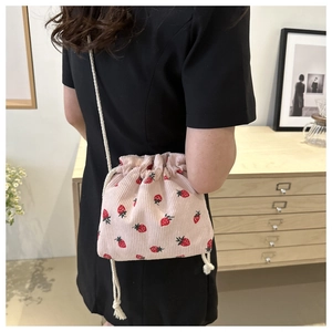 Detail of pink corduroy strawberry bucket bag with white cotton rope shoulder strap