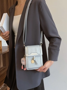 Silver leather mini crossbody phone bag with gold logo, tassel, and cute fur ball charm