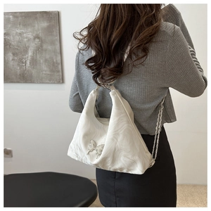 Detailed back view of a white marble pattern shoulder bag with a silver butterfly buckle