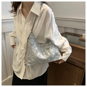 Close-up of silver marble texture bag featuring metallic butterfly and elegant chain