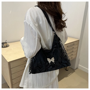 Detail of black water ripple shoulder bag with silver butterfly buckle and metal chain