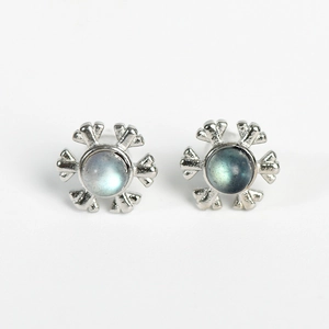 Silver snowflake earrings with iridescent blue moonstone center in a minimalist style