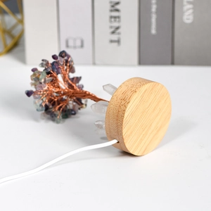 Crystal tree lamp with natural amethyst leaves on a round wooden base with USB cable