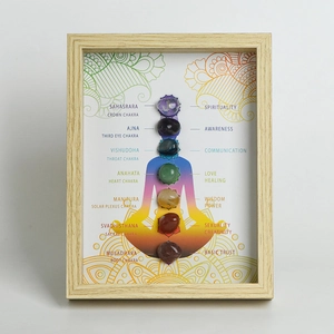 Minimalist wooden photo frame with seven chakra healing stones and meditation silhouette