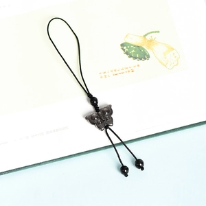 Natural silver obsidian butterfly pendant with handmade black woven cord on book