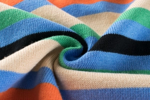 Makroaufnahme von bunt gestreiftem Strickstoff mit weicher Textur für Kinderpullover