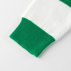Kids knitted sweater cuff with green ribbed edge and white waffle knit texture