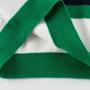 Close-up of green and white striped waffle knit sweater with ribbed cuffs for children