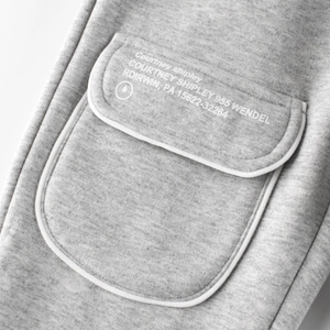 Fleece-lined kids joggers in heather grey featuring a stylish white piped pocket detail