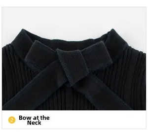 Detail of elegant black ribbed knit texture and fixed cross bowknot on the girl's sweater