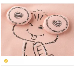 Detail of pink fleece sweatshirt featuring 3D cartoon animal ears and letter graphics