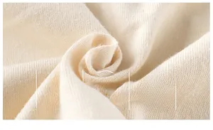 Macro shot of soft, breathable cream knit fabric showing fine texture and fiber detail