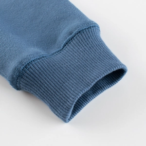Gros plan des poignets côtelés classiques d'un sweat en polaire bleu pour enfants